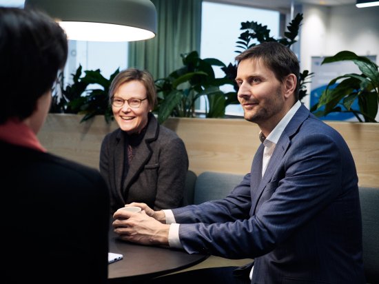 Mann og dame i dress sittende ved et bord